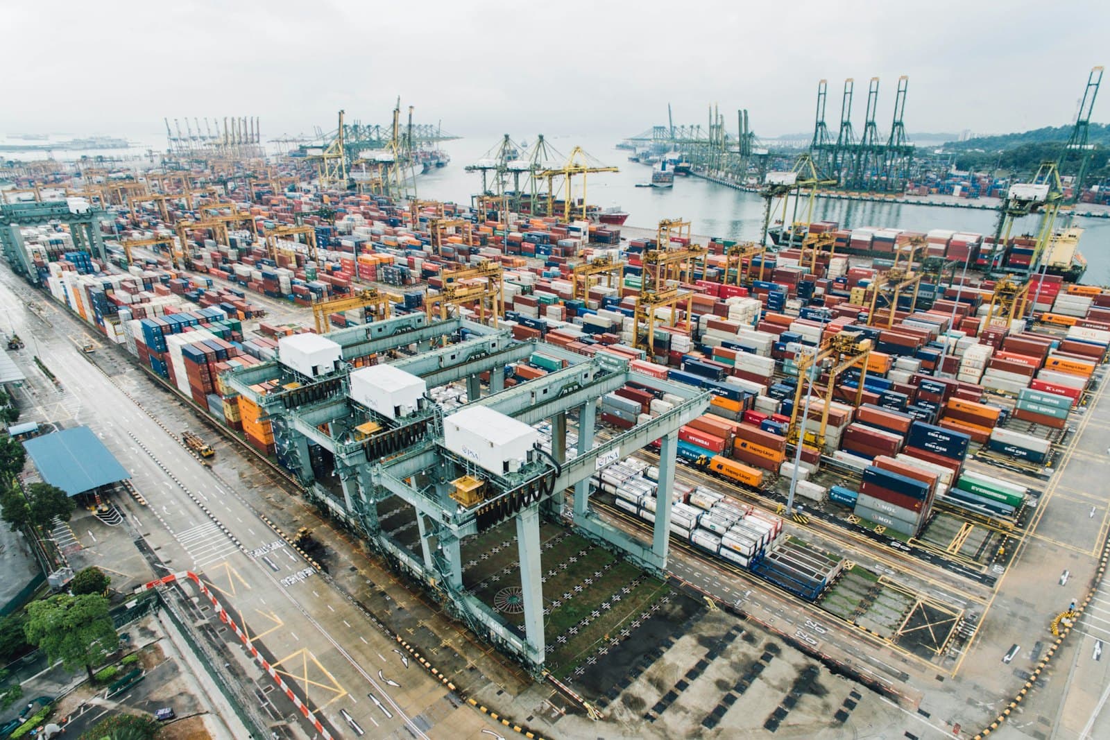 Aerial view of a container port with stacked freight and gantry cranes